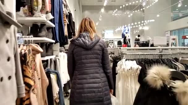 Young woman chooses clothes — Stock Video