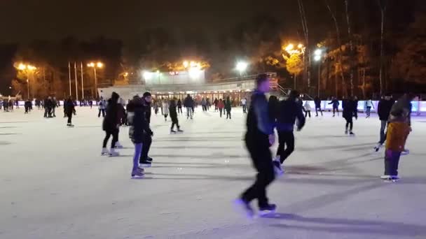 Mensen schaatsen op de ijsbaan in het park Sokolniki — Stockvideo