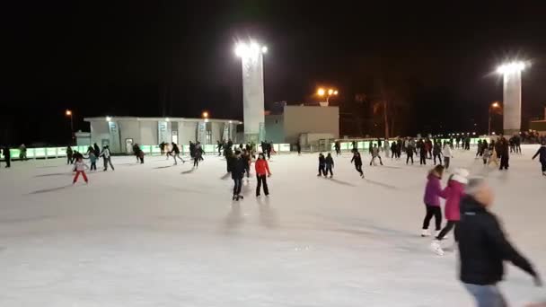 La gente patina en la pista de patinaje en el parque Sokolniki — Vídeos de Stock