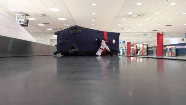 Valiza pierdută se deplasează încet pe banda transportoare din aeroport — Videoclip de stoc