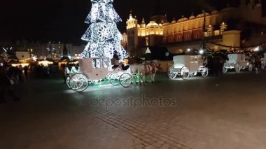 İnsanlar Noel pazarı eski şehrin ana Meydanı'nda ziyaret