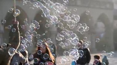 Üfleme kabarcıklar, mutlu turistler ve onlarla oynamak çocuk genç adam