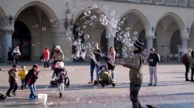 Üfleme kabarcıklar, mutlu turistler ve onlarla oynamak çocuk genç adam