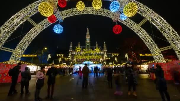 La gente visita el mercado de Navidad cerca del ayuntamiento por la noche — Vídeo de stock