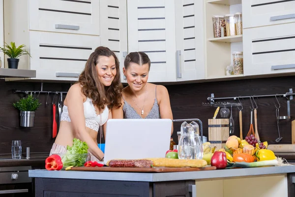 Due sorelle gemelle che cercano la ricetta dell'insalata su Internet — Foto Stock