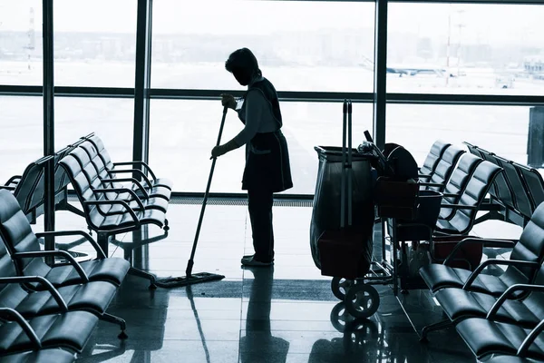 Працівник прибирає підлогу в аеропорту — стокове фото