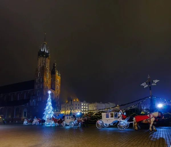 Carriages for riding tourists on the background of Mariacki cathedral — Stock Photo, Image