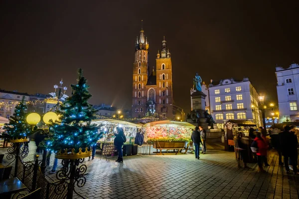 La gente visita el mercado de Navidad en la plaza principal de la ciudad vieja —  Fotos de Stock