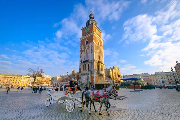 Vagnar för ridning turister på bakgrunden av rådhuset — Stockfoto