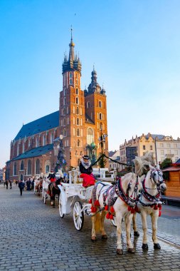 Turistler Mariacki Katedrali arka plan üzerinde sürme için küçük yük arabalar