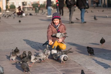 Kız Yaşı 6-8 yıl içinde eski şehrin ana Meydanı'nda güvercin besleme