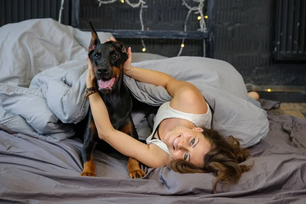 Jovem mulher bonita com cão doberman preto — Fotografia de Stock