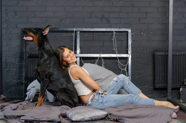 Jovem mulher bonita com cão doberman preto — Fotografia de Stock