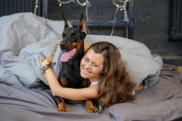 Jovem mulher bonita com cão doberman preto — Fotografia de Stock