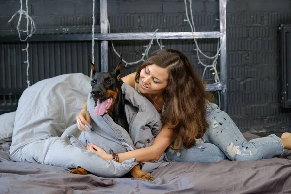 Giovane bella donna con cane doberman nero — Foto Stock