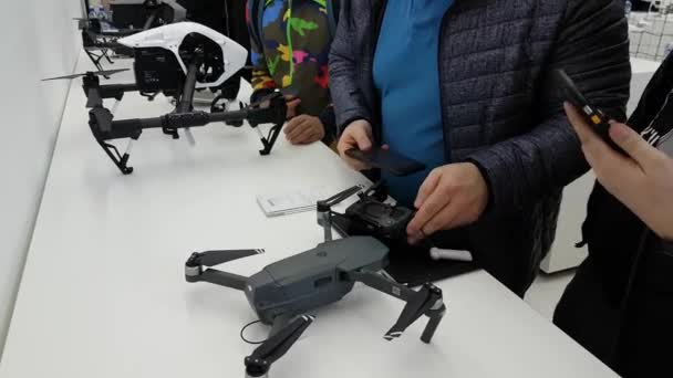 Klanten kijken quadrocopters bij de opening van Dji winkel — Stockvideo