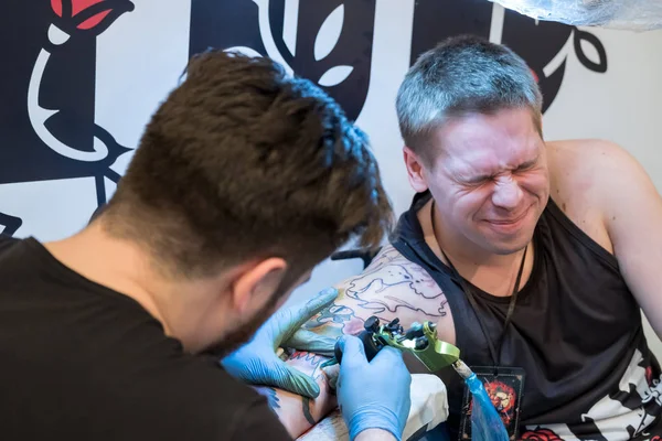 Artista haciendo un tatuaje para el visitante Tattoofest — Foto de Stock