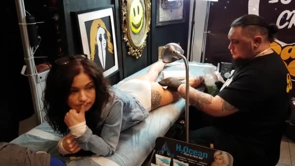 Kunstenaar maken een tatoeage voor Tattoofest bezoeker — Stockvideo