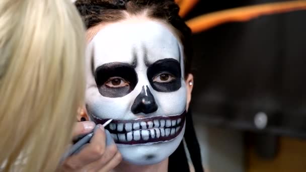 Make-up artist farby czaszki na twarzy dziewczyny — Wideo stockowe