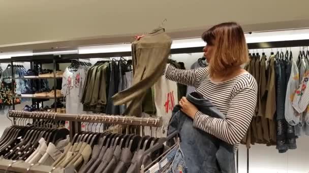 Jeune femme choisit des vêtements — Video