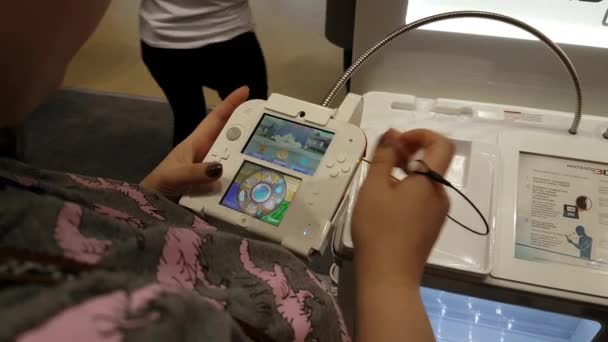 Visitantes testando consolas Nintendo — Vídeo de Stock