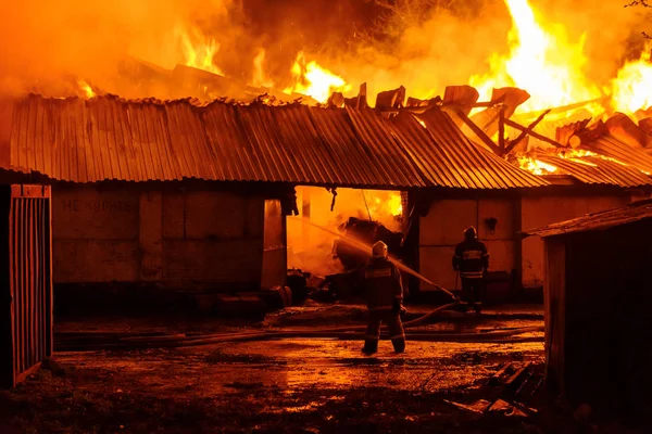 Feuerwehrleute löschen einen Brand — Stockfoto