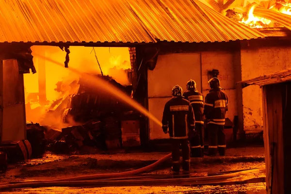 Bombeiros extinguem um incêndio — Fotografia de Stock