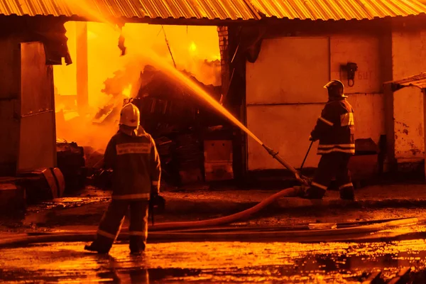 Brandweerlieden blussen een brand — Stockfoto