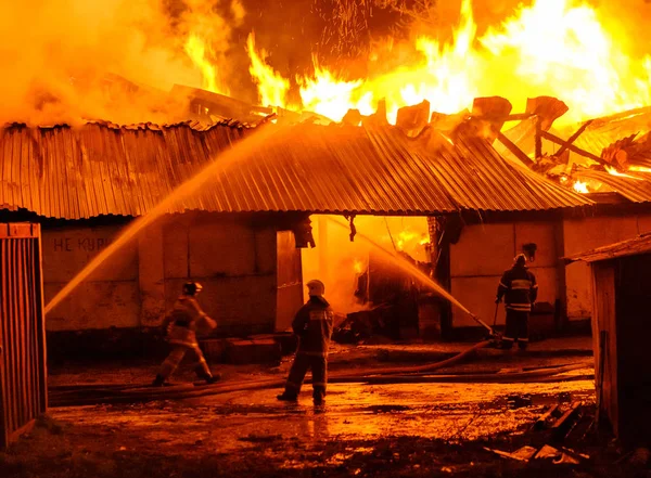 Brandweerlieden blussen een brand — Stockfoto