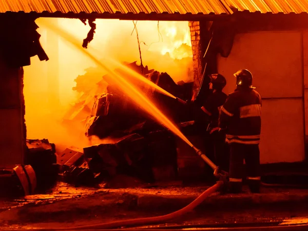 Brandweerlieden blussen een brand — Stockfoto