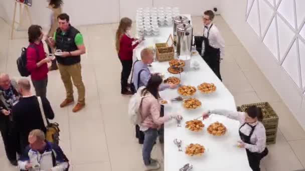 Leute nehmen auf einer Konferenz Brötchen mit Rosinen mit auf eine Kaffeepause — Stockvideo