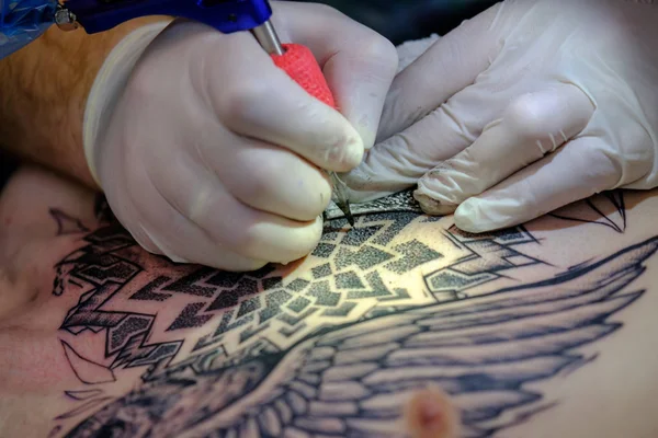 Artista haciendo un tatuaje para el visitante Tattoofest — Foto de Stock