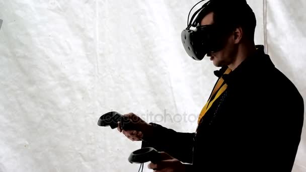 Visitante testa capacete realidade virtual e gamepads — Vídeo de Stock