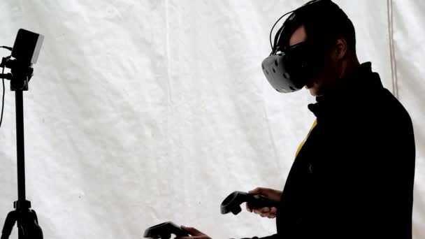 Visitante testa capacete realidade virtual e gamepads — Vídeo de Stock