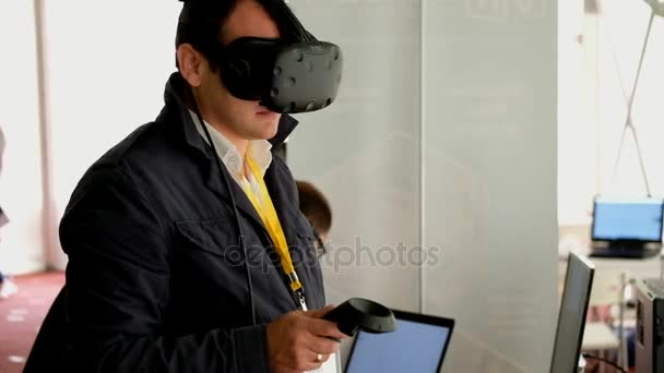 Besucher testet Virtual-Reality-Helm und Gamepads — Stockvideo