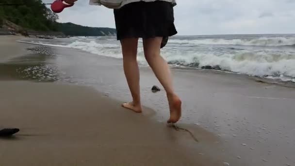 Молодая женщина прогуливается по пляжу — стоковое видео