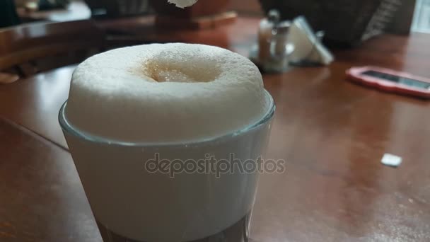 Socker som hälls i en kopp cappuccino — Stockvideo