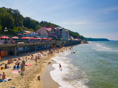 İnsanlar sakin ve güneşli yaz gününde Baltık Denizi sahilinde güneşlenirken