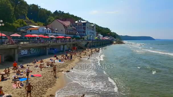 Menschen entspannen und sonnen sich an der Ostseeküste an sonnigen Sommertagen — Stockvideo