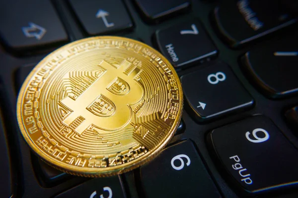 Moeda bitcoin dourada no teclado do laptop preto . — Fotografia de Stock