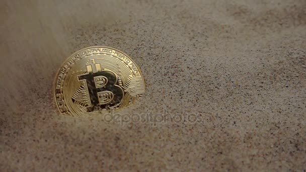 Goldene Bitcoin-Münze ist mit Sand bedeckt — Stockvideo