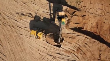 Ekskavatör kum kazılar ve o bir kamyona yük.