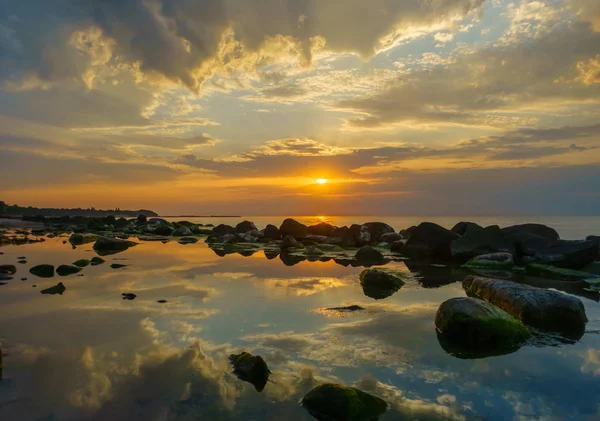 Pôr do sol sobre o mar, pedras em primeiro plano — Fotografia de Stock