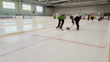 Ekip üyeleri IX uluslararası Medexpert Curling Kupası sırasında curling oynamak