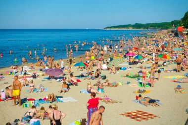 İnsanlar sakin ve güneşli yaz gününde Baltık Denizi sahilinde güneşlenirken
