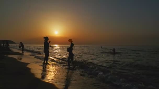 La gente juega pelota en la playa — Vídeo de stock