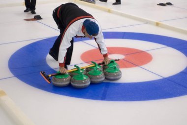 Ekip üyeleri IX uluslararası Medexpert Curling Kupası sırasında curling oynamak