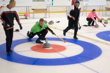 Ekip üyeleri IX uluslararası Medexpert Curling Kupası sırasında curling oynamak