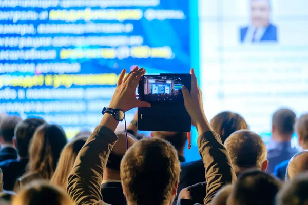 Чоловік фотографує презентацію в конференц-залі — стокове фото