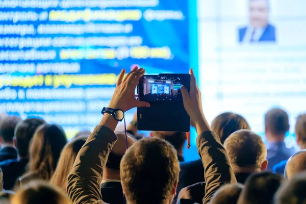 Чоловік фотографує презентацію в конференц-залі — стокове фото